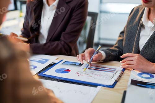 Preview: Businesswomen analyzing financial charts and graphs during a meeting