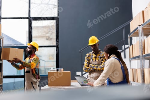Preview: African american warehouse managers discussing pick ticket on laptop