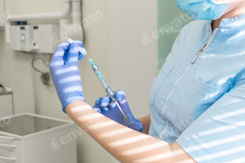 Preview: Doctor in medical gown and gloves holds syringe in her hand for injections and vaccinations. Health