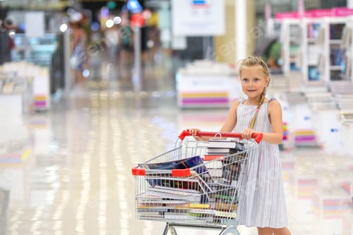 Preview: The child has filled a basket of books. Little girl in the book store.