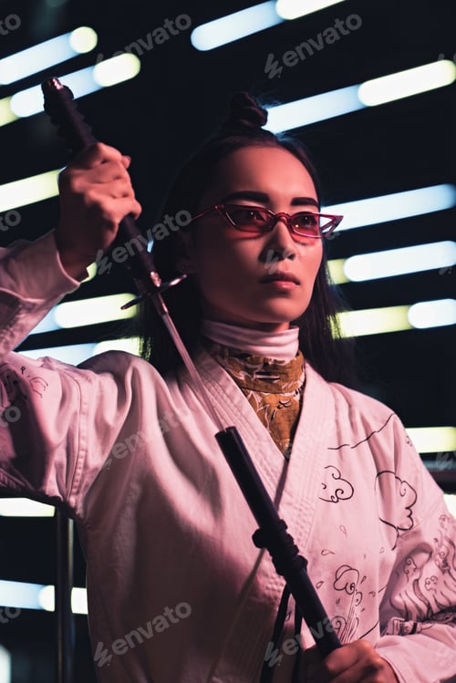 Preview: attractive asian girl in white kimono taking katana on street with neon light in evening, city of