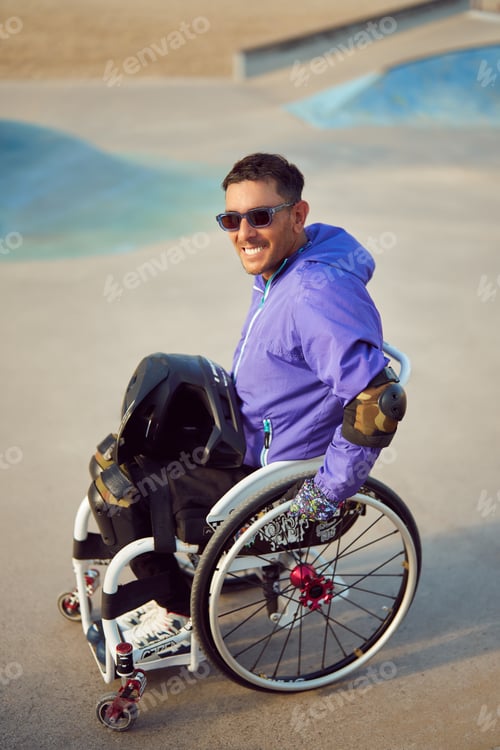 Preview: portrait smiling athlete man with disability in wheelchair at skatepark