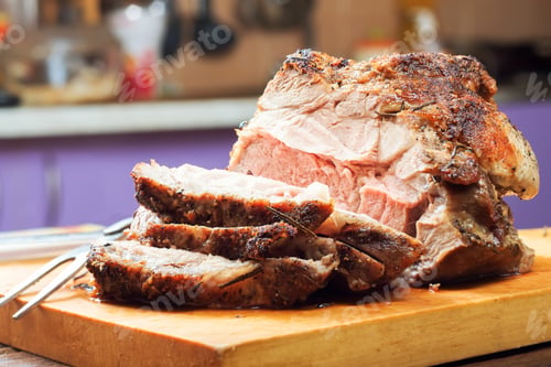 Preview: Baked pork meat with spices on wooden cutting board