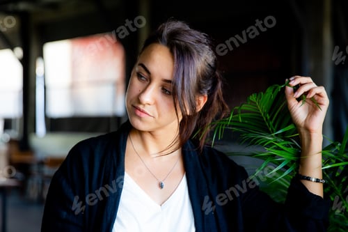 Preview: Portrait of beautiful brunette woman with amazing blue eyes looking aside wit tropical palm by