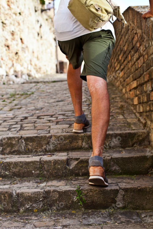 Preview: Walking upstairs: closeup view of man's legs brown leather shoes going upstairs.