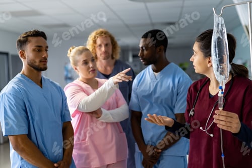 Preview: Caucasian female doctor with diverse trainee doctors applying drip at hospital