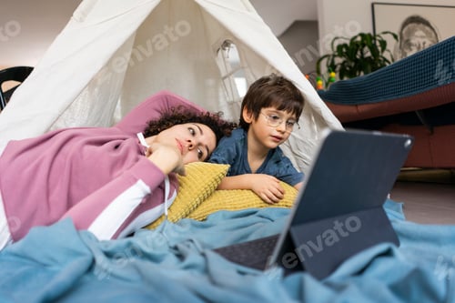 Preview: Mother and son lying in play tent, watching movie on tablet