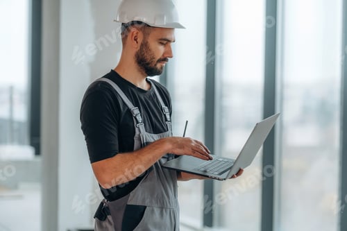 Preview: Wireless device, holding laptop. A man is renovating an unfinished room