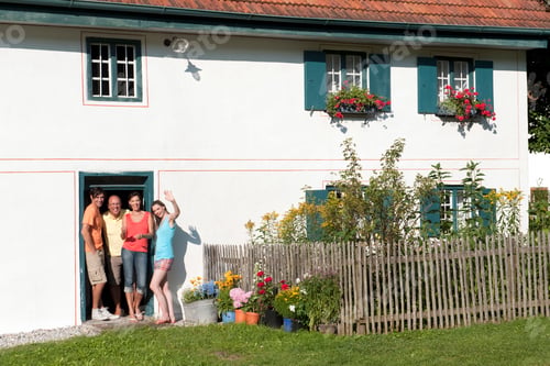 Preview: Germany, Bavaria, Four persons waving in front of entry door, portrait