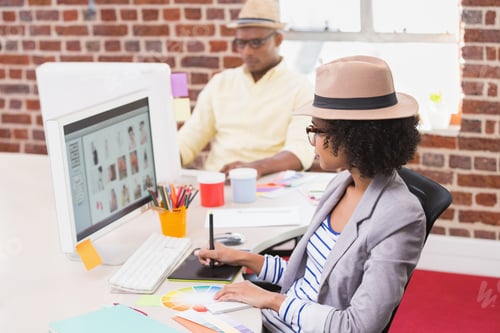 Preview: Side View Of Female Photo Editor Using Digitizer In The Office