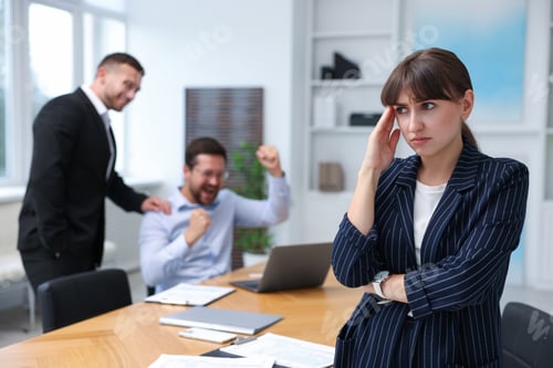 Preview: Woman feeling jealous of her colleague's success in office, selective focus