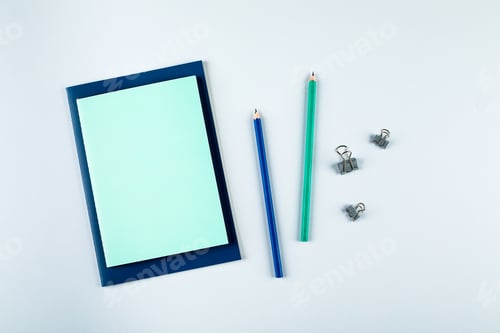 Preview: Blue and green notebooks with stationary objects on grey background. Top view, flat lay, copy space
