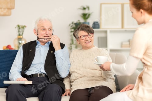 Senior Couple Relaxing with Caregiver at Home