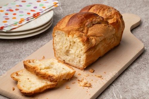 Preview: Fresh baked loaf of croissant bread and slices on a cutting board