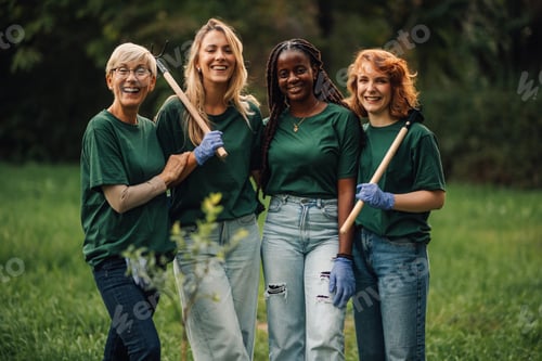 Preview: Four volunteers smiling and holding gardening tools