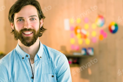 Preview: Man wearing blue shirt standing left at wood panel wall with circular palette, notes, copy space