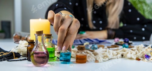Preview: Woman fortune teller prepares a potion. Selective focus.