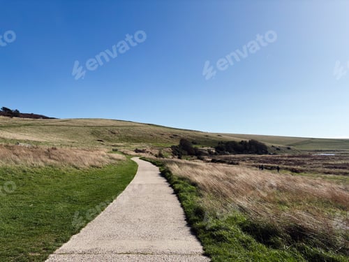 Preview: Winding gravel path through rolling hills under a clear blue sky in East Sussex Seven Sisters area