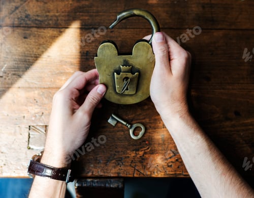 Preview: Hands Holding Unlock Padlock and Key on Wooden Table