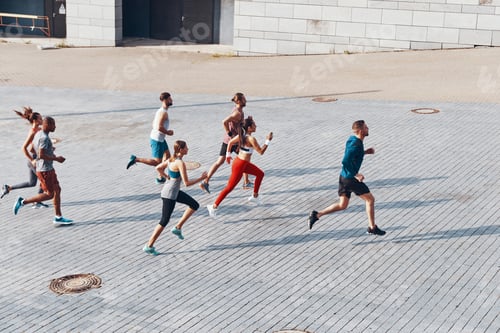 Preview: Full length top view of young people in sports clothing jogging while exercising outdoors