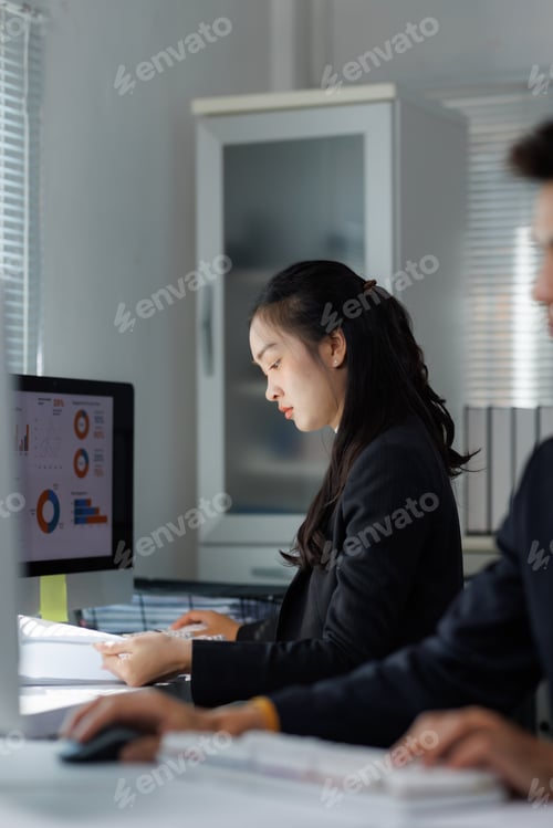 Preview: Young businesswoman analyzing business data on computer