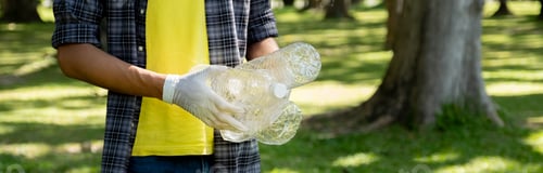 Preview: Hand holding plastic bottle waste, picking up trash and putting it in the black garbage bag