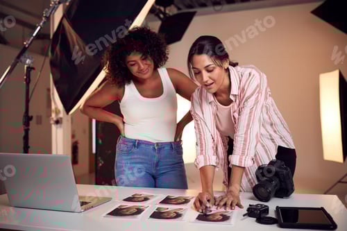 Preview: Photographer With Female Client Editing Images From Portrait Photo Shoot In Studio