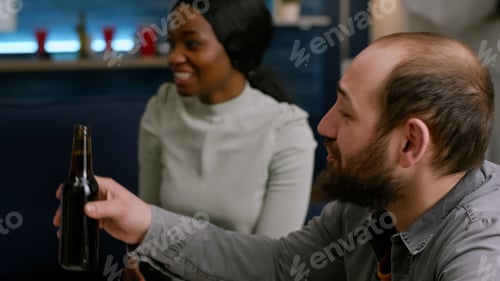 Preview: Mixed race friends cheering bottles of beer spending time together