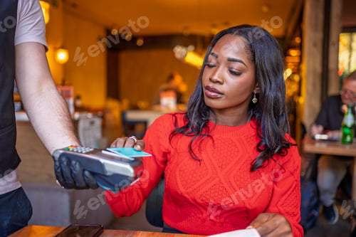 Preview: Customer paying with contactless credit card in restaurant