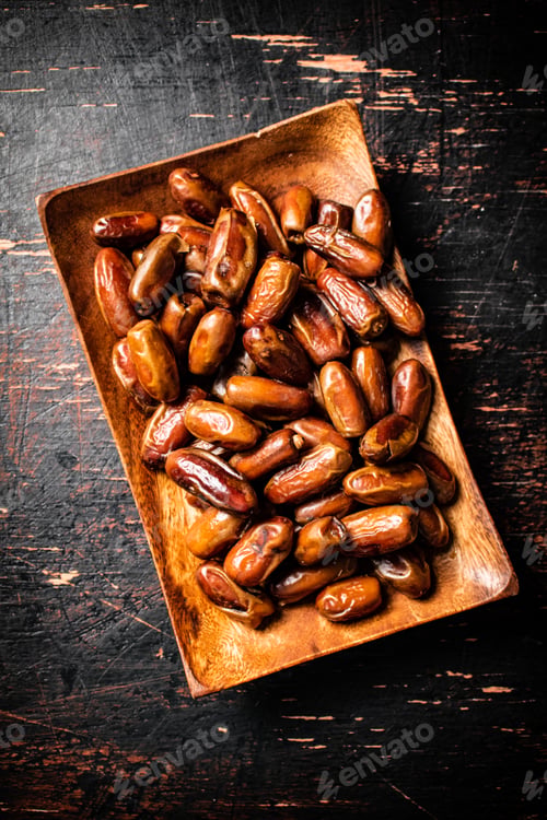 Preview: Delicious dates on a wooden plate.