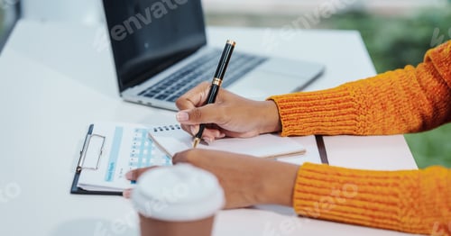 Person writing on a notebook at a desk