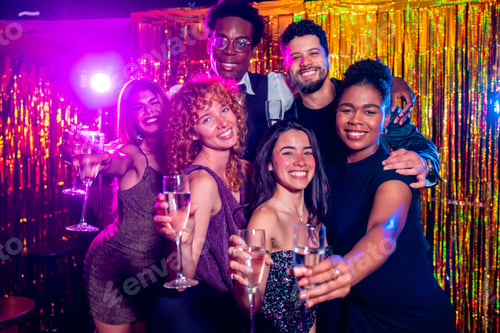 Preview: Friends toasting champagne flutes at trendy nightclub party