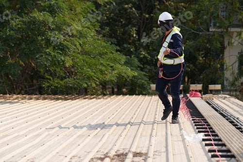 Preview: Engineer installing solar cell panels on roof.