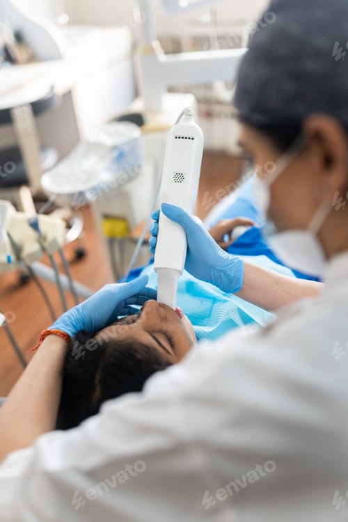 Preview: Indian woman receiving intraoral scanning with innovative machine at clinic