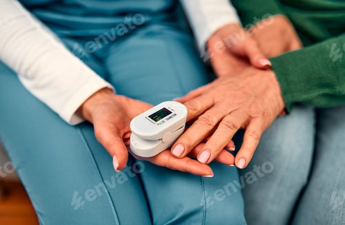 Preview: A healthcare worker measuring the oxygen saturation and pulse of an elderly woman using a pulse oxim