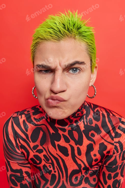Preview: Grumpy displeased punk woman has sulking expression purses lips being discontent with something wear