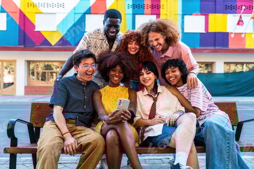 Preview: Multiethnic group of young friends meeting and having fun outdoors