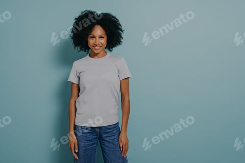Preview: Delighted young african female posing isolated over blue background with pleasant smile