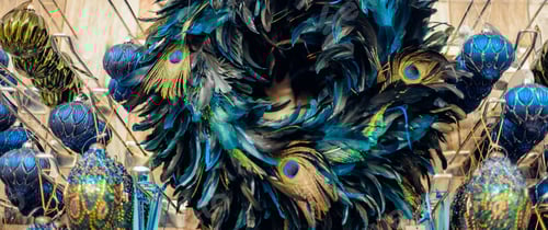 Preview: Close up peacock feather wreath with navy blue and golden balls in shop's display. Close up creative