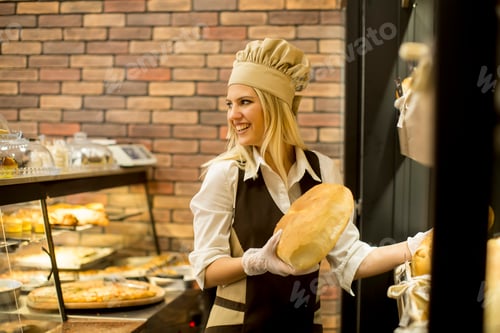 Preview: Pretty young woman selling fresh bread in the bakery