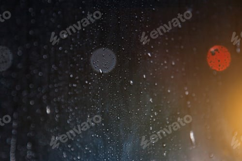 Preview: Abstract background with raindrops on window and night blurred light