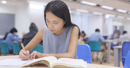 Preview: Student working on her homework at library