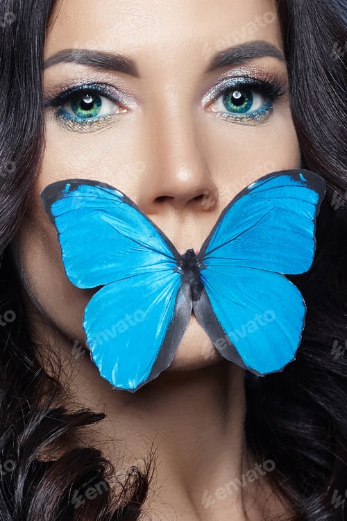 Preview: Beautiful mysterious woman with butterflies blue color on her face, brunette and paper artificial