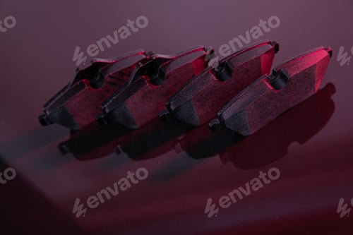 Preview: set of car brake pads for car safety on stylish red background, depth of field photography