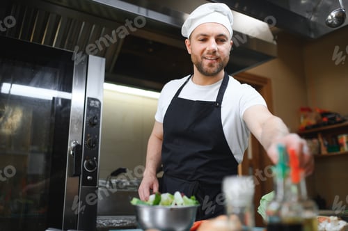 Preview: Portrait of handsome positive chef cook at the restaurant kitchen