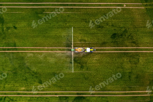 Vista previa: top down view of the tractor spraying the chemicals on the large green field, agriculture concept