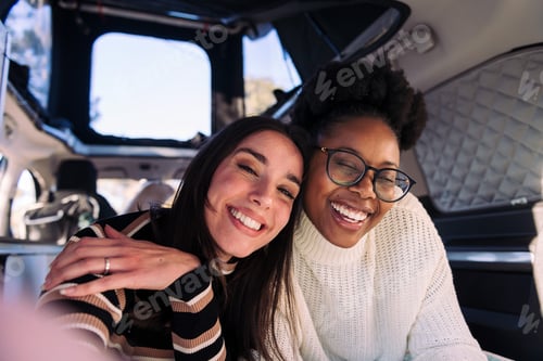 Preview: two women having fun taking a selfie in camper van
