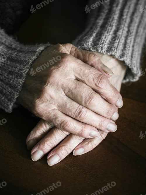 Preview: Close up of senior woman hands on table