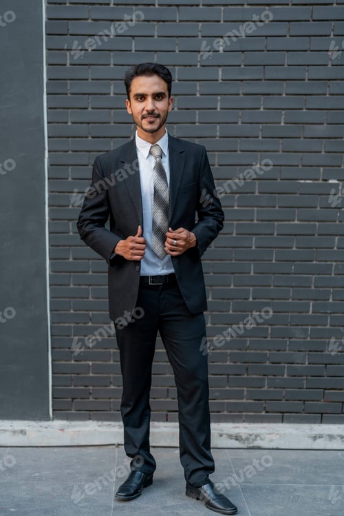 Preview: Confident young businessman standing in a formal black suit