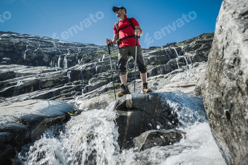 Preview: Hiker on the Glacial Valley Trail with Hundreds of Waterfalls in a Background.